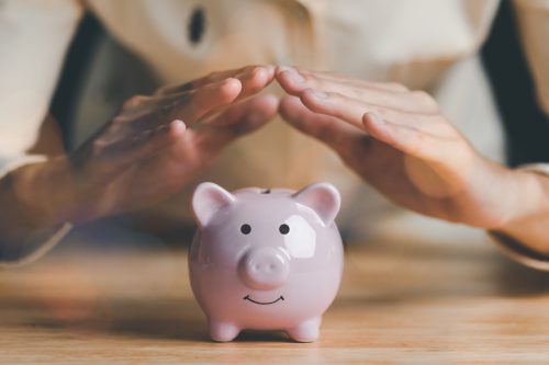 A man represents protection and protection of safety of the piggy bank ,Insurance management planning ,health care and finance ,property and family risk reduction,life and property protection planning